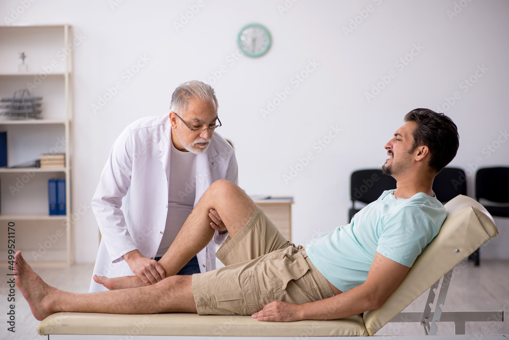 Obraz premium Young male patient visiting old male doctor