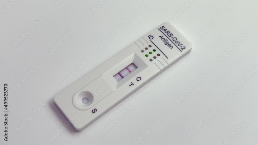 Performing COVID-19 antigen flow test. The test indicates a positive result. Wide framing. Performing COVID-19 antigen flow test. The test indicates a positive result. Wide framing.