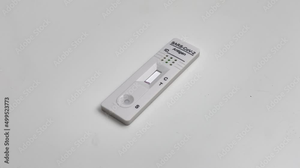 Performing COVID-19 antigen flow test. Flow to a positive result on the test pad. Wide framing. Quick speed. Performing COVID-19 antigen flow test. Flow to a positive result on the test pad. Wide framing. Quick speed.