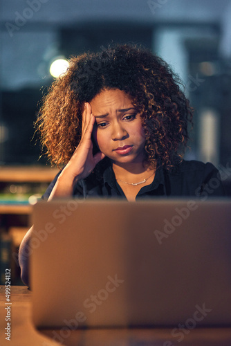 Its just one thing after another. Shot of a young businesswoman experiencing stress during a late night at work.