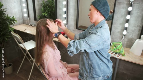 make-up artist blends powder on model's face
