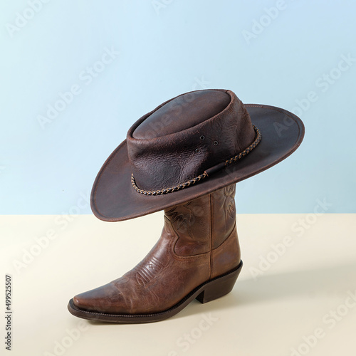Boot shoes and texas wild west american cowboy hat as minimal concept poster and rural rodeo and farm symbol.