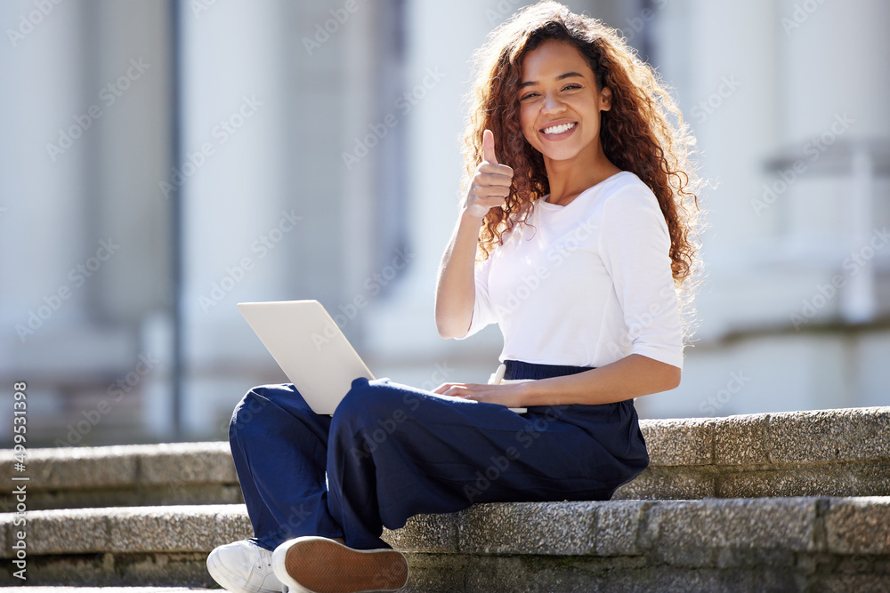 Fototapeta premium Happiness depends upon ourselves. Shot of a young woman using a laptop on the steps at college.