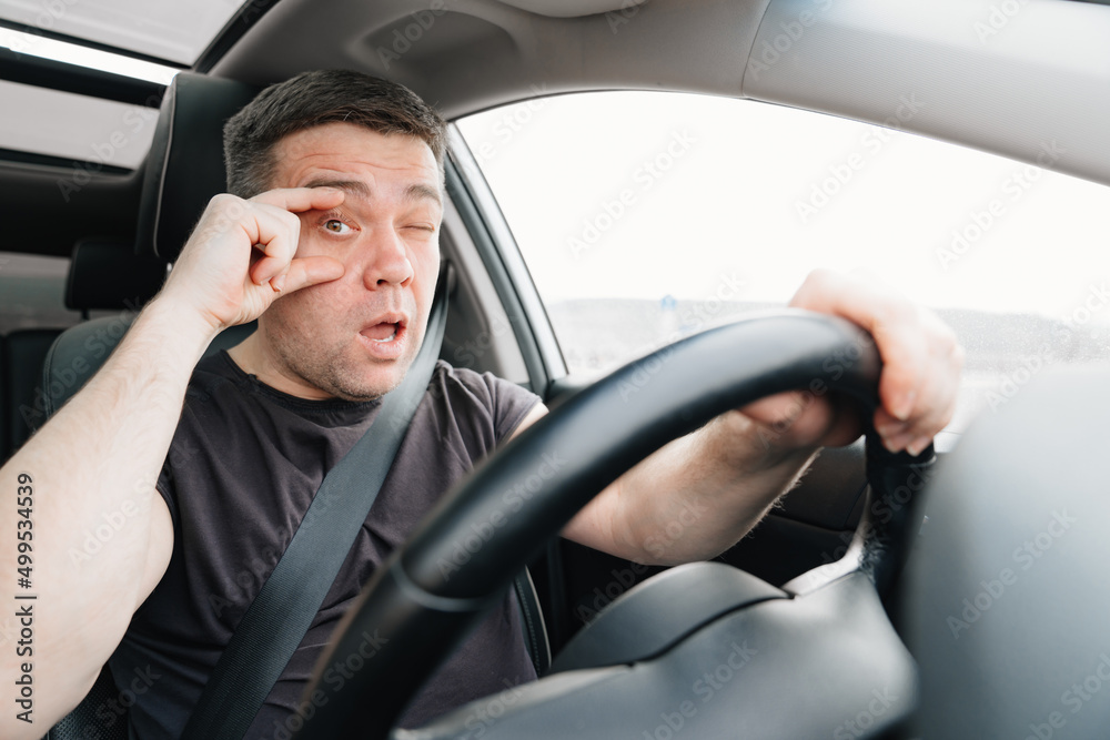 a sleepy man with closing eyes drives a car on the highway a sleepy man with closing eyes drives a car on the highway