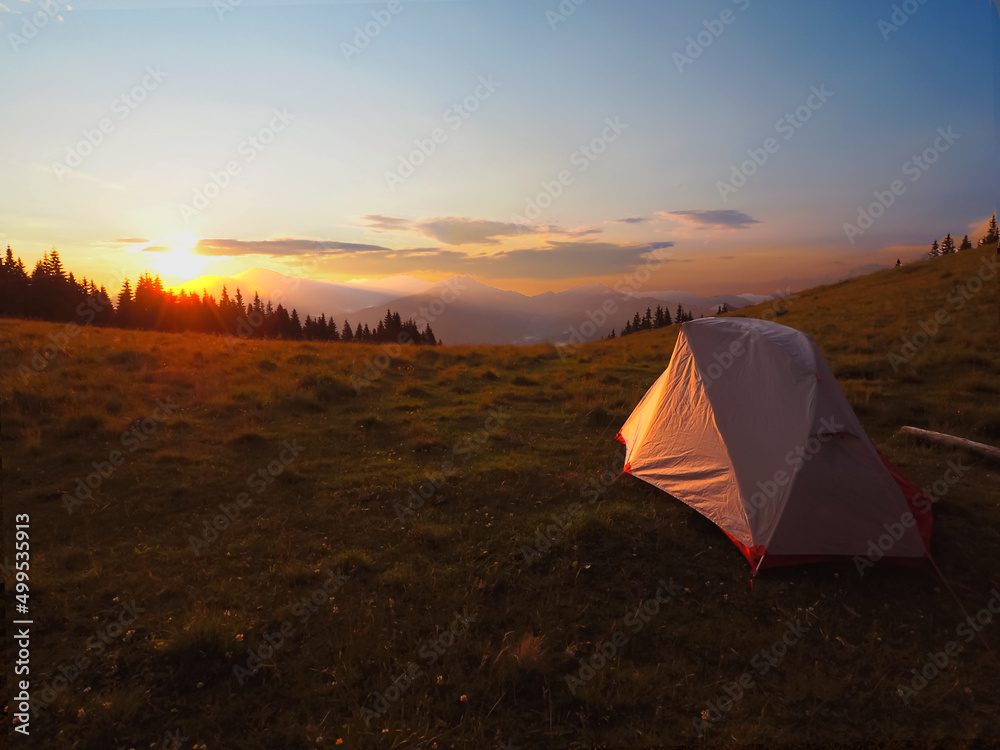  view of tourist tent in mountains at sunrise or sunset 