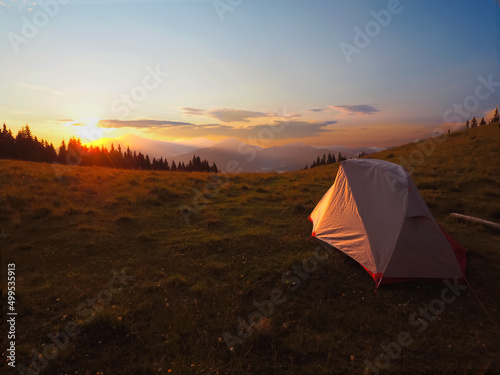  view of tourist tent in mountains at sunrise or sunset 