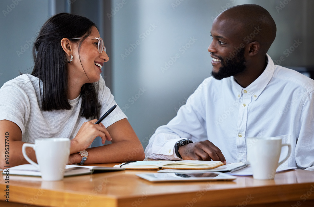 Always winning, in due time. Shot of two businesspeople sitting at a desk in a modern office.