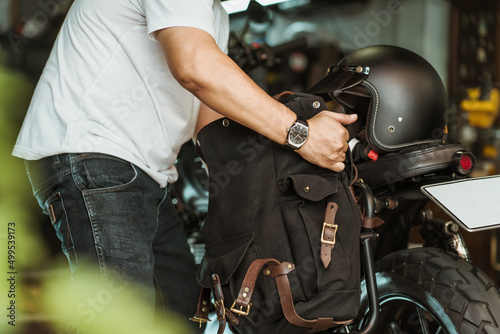 rider install a motorcycle saddlebag or side bag on luggage bracket vintage motorbike motorcycle travel concept. selective focus.