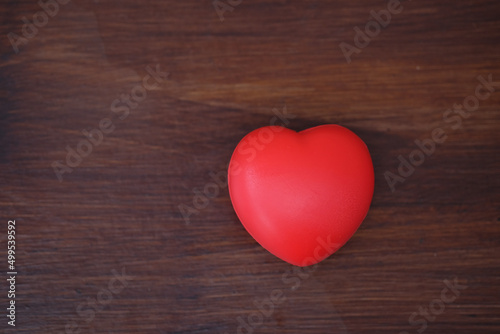 Red heart on wood table. Concept for charity, health insurance, love, international cardiology day.