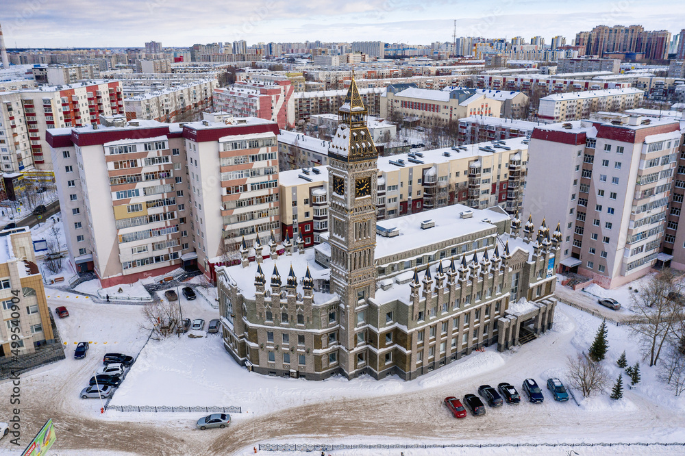 Surgut city in winter. Residential area, foreign language school - Big Ben. Aerial view.