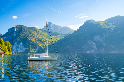 A yacht against the backdrop of the mountains in Switzerland. Calm water and bright sunny day. A popular place to travel and relax. © biletskiyevgeniy.com
