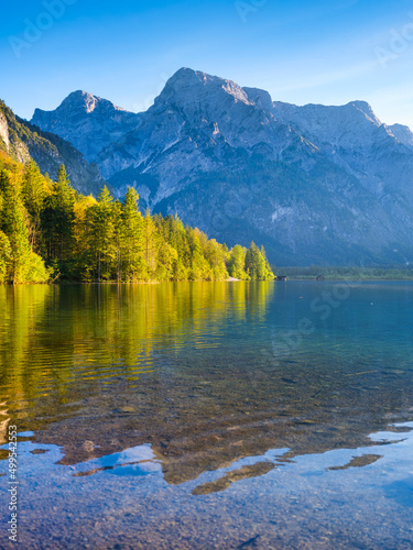 High mountains and reflection on the surface of the lake. The forest near the...