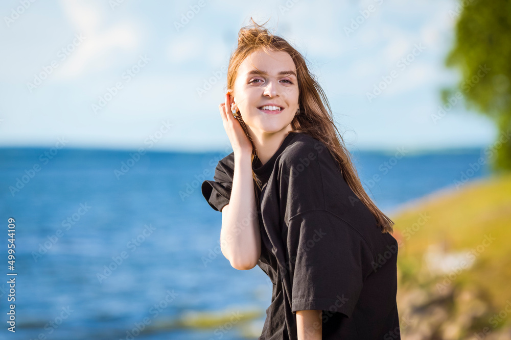 Cute Smiling Winsome Relaxing Caucasian Blond Female Girl Posing Outdoors While Sitting With Positive Expression Outdoors At Sunny Day Near Seashore Cute Smiling Winsome Relaxing Caucasian Blond Female Girl Posing Outdoors While Sitting With Positive Expression Outdoors At Sunny Day Near Seashore