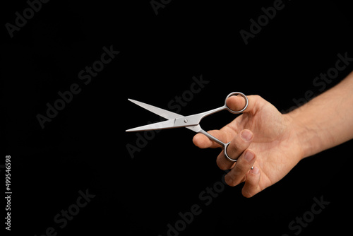 hand of a man handing a scissors