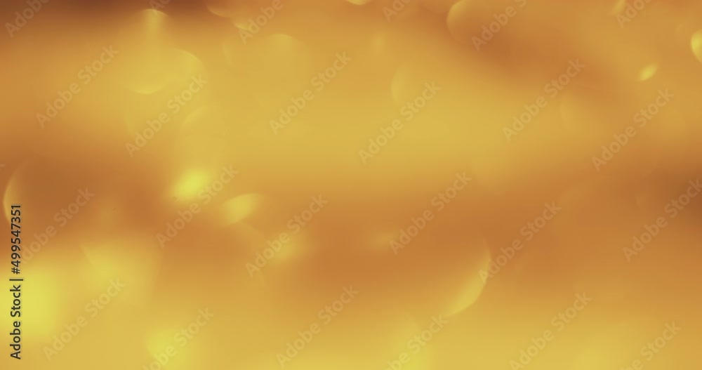 Bokeh glow. Light flare overlay. Sequin reflection. Defocused gold shiny circles motion on orange color gradient abstract background shot on RED Cinema camera.