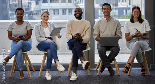 What do you bring to the table. Shot of a group of businesspeople using wireless devices while waiting in line for an interview.