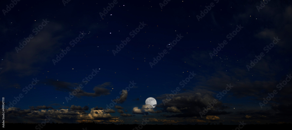Panorama of night sky with clouds and stars. Moonlight.