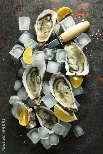 Concept of delicious seafood, oysters on dark textured background