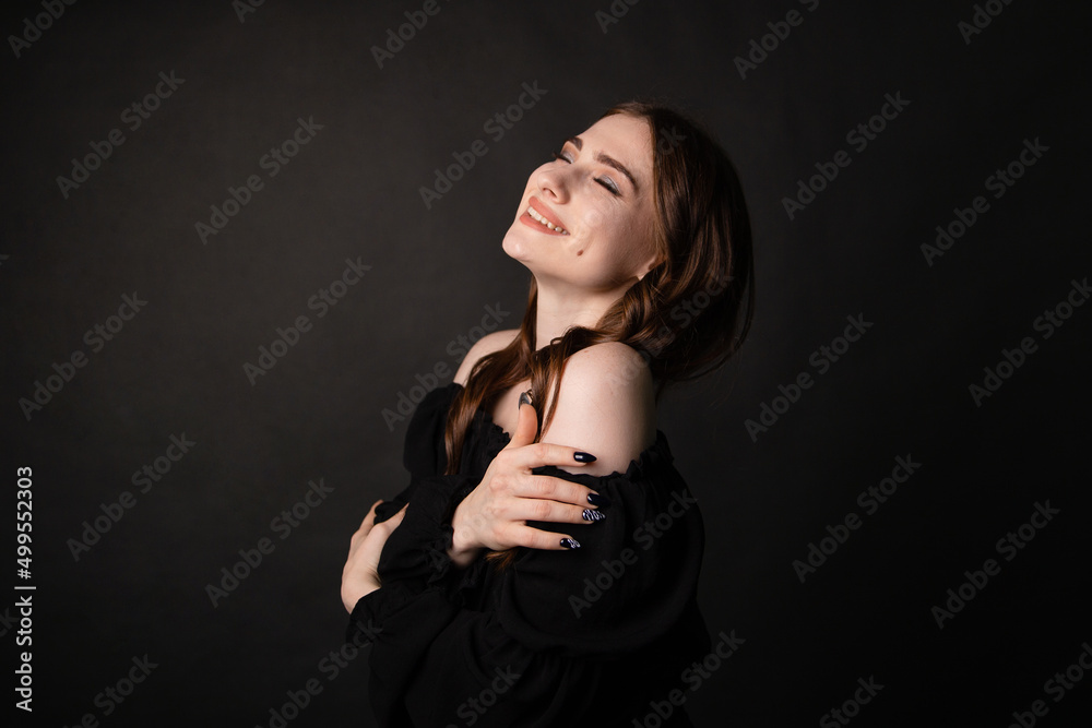 Portrait of a beautiful woman with long hair on a dark background.Girl with a charming smile. Portrait of a beautiful woman with long hair on a dark background.Girl with a charming smile.