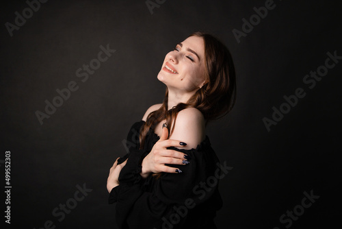 Portrait of a beautiful woman with long hair on a dark background.Girl with a charming smile.
