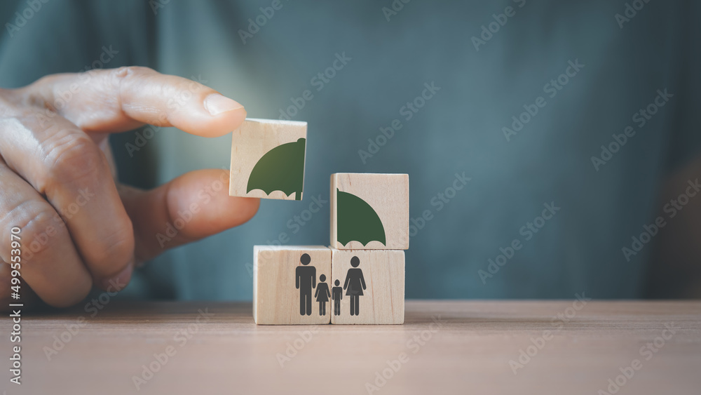 senior's hand complete umbrella over family icon on wooden cube blocks, for life or group insurance - obrazy, fototapety, plakaty 