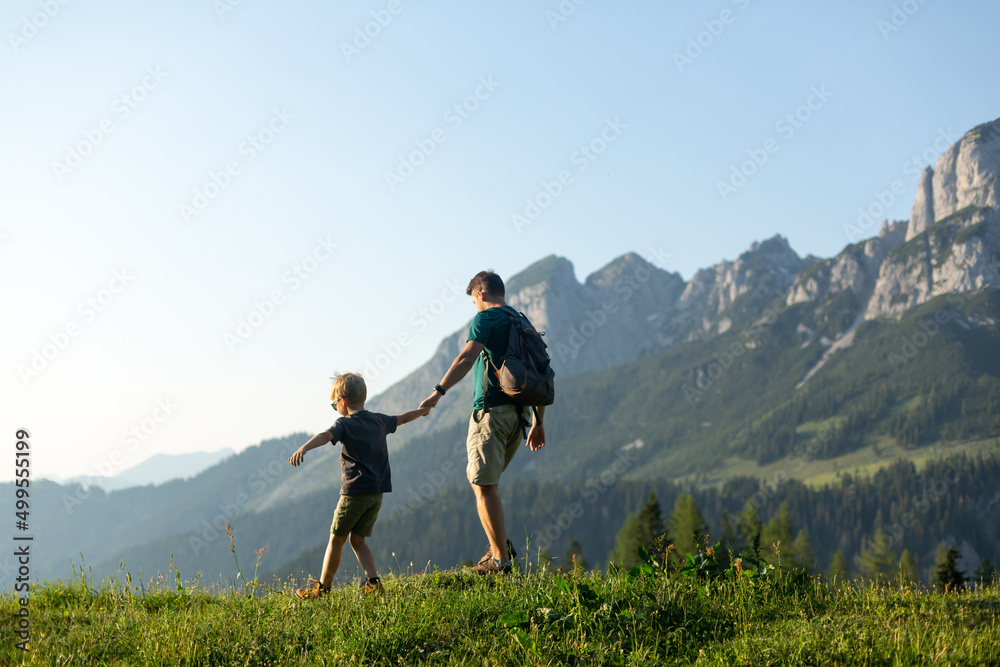 Family time in mountains. Father and son hiking in the Austrian Alps