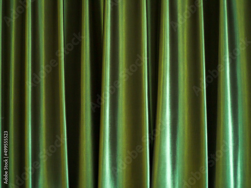 Illustration of green curtains, vertical curls and black shadows.