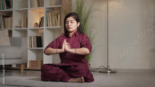 Meditation indoors. Yoga wellness. Spiritual practice. Peaceful mindful woman exercising mudra mahamayuri dhyana gestures in lotus position at home living room. photo