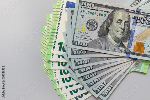 Exchange rate. American money banknote bills with European cash money banknotes, stacks of USA dollars, 100 $ one hundred dollars and €100 one hundred Euros. Exchange rate. Isolated on gray background