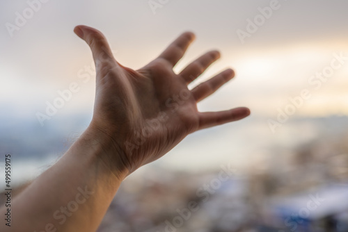 Hand of a man reaching to towards sky. © Vladimir Arndt