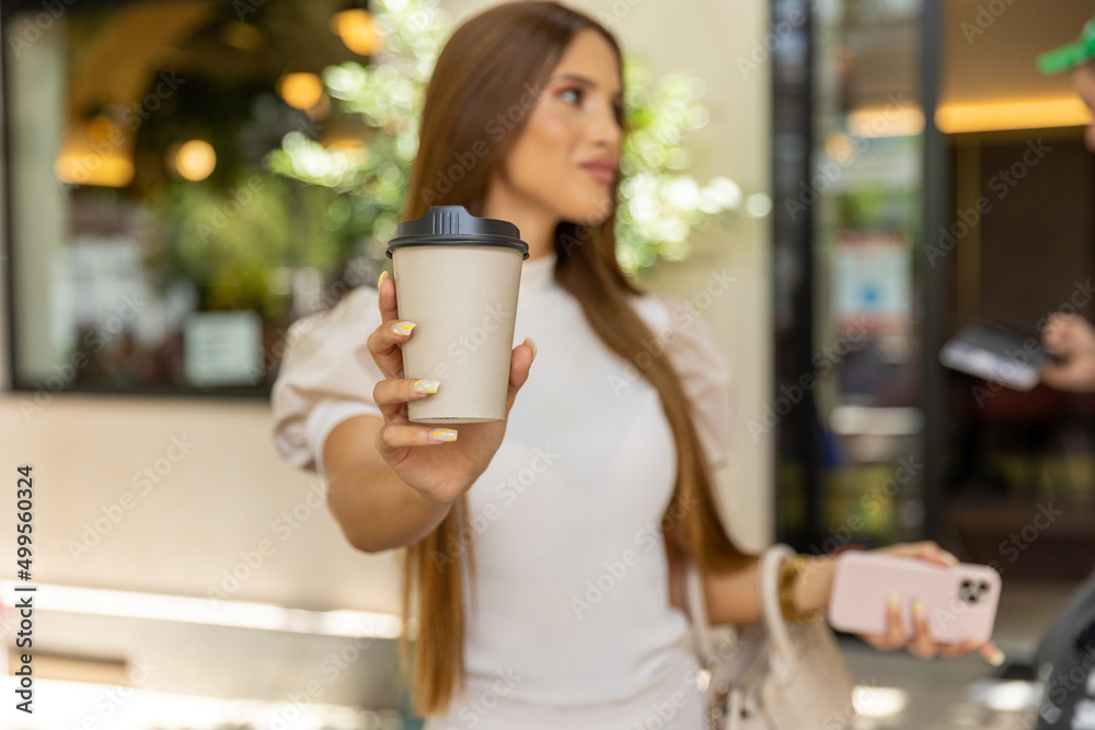Young woman holding take away carton coffee cup, copy space Young woman holding take away carton coffee cup, copy space