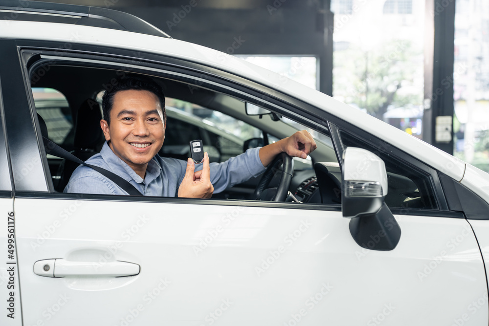 Asian attractive man customer hold remote car key while sit in vehicle