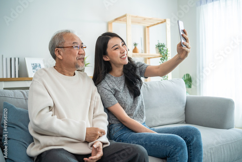 Asian lovely family, young daughter use phone selfie with older father