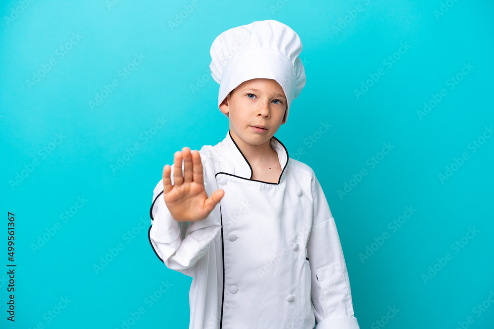 Little chef boy isolated on blue background making stop gesture Little chef boy isolated on blue background making stop gesture