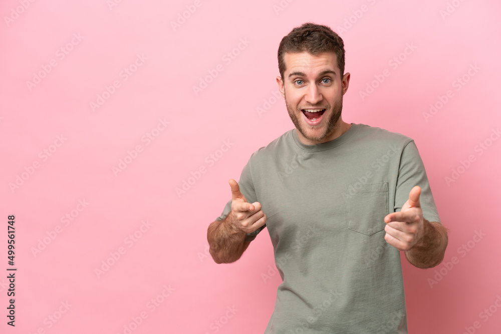 Young caucasian man isolated on pink background pointing to the front and smiling Young caucasian man isolated on pink background pointing to the front and smiling