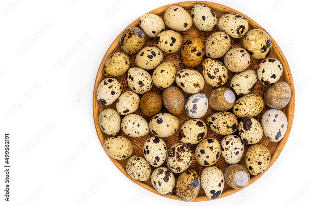 Raw quail eggs on a white background on a plate, top view, healthy eating concept Raw quail eggs on a white background on a plate, top view, healthy eating concept
