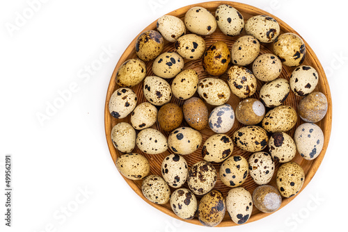 Raw quail eggs on a white background on a plate, top view, healthy eating concept