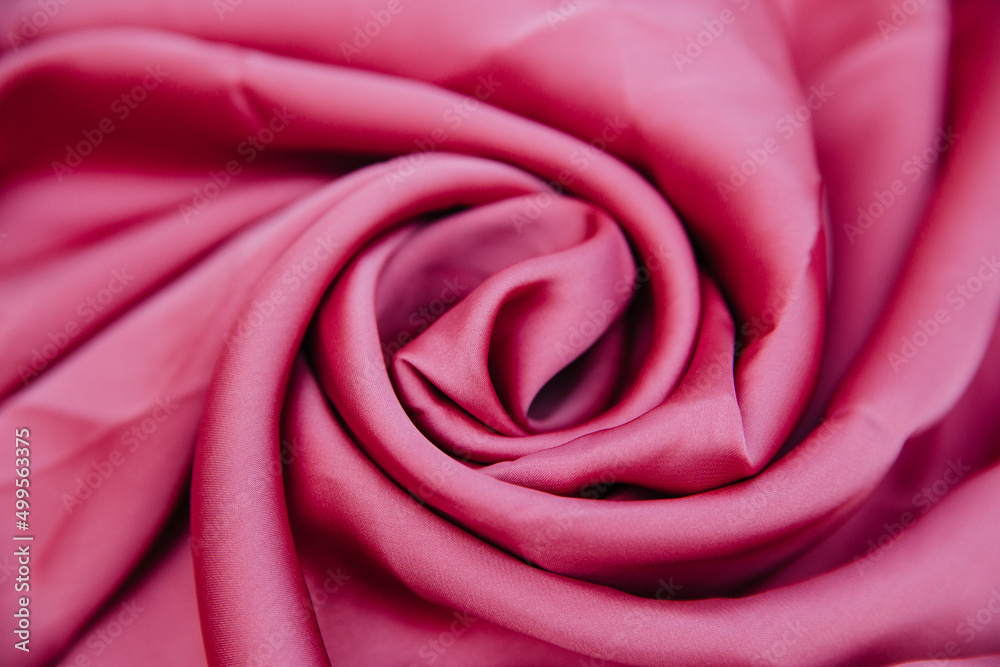 A pink wrinkled fabric lies in folds on a draped table.