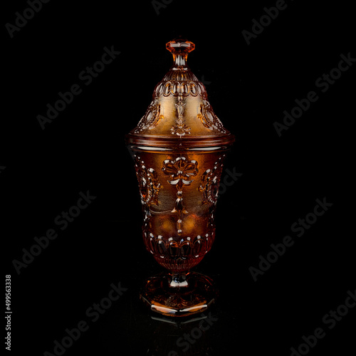 Wallpaper Mural crystal antique orange urn. vintage colored glass urn with engraving on a black isolated background Torontodigital.ca