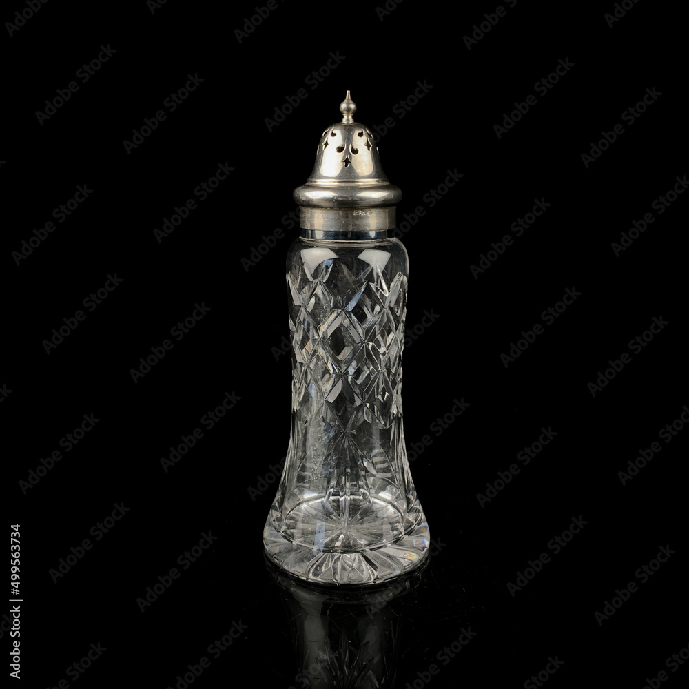 crystal vessel for pepper and salt. glass bottle for pepper and salt on black isolated background crystal vessel for pepper and salt. glass bottle for pepper and salt on black isolated background