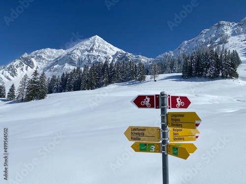 Hiking markings and orientation signs with signposts for navigating in the idyllic winter ambience on the Alpstein mountain massif and in the Swiss Alps - Nesslau, Switzerland / Schweiz