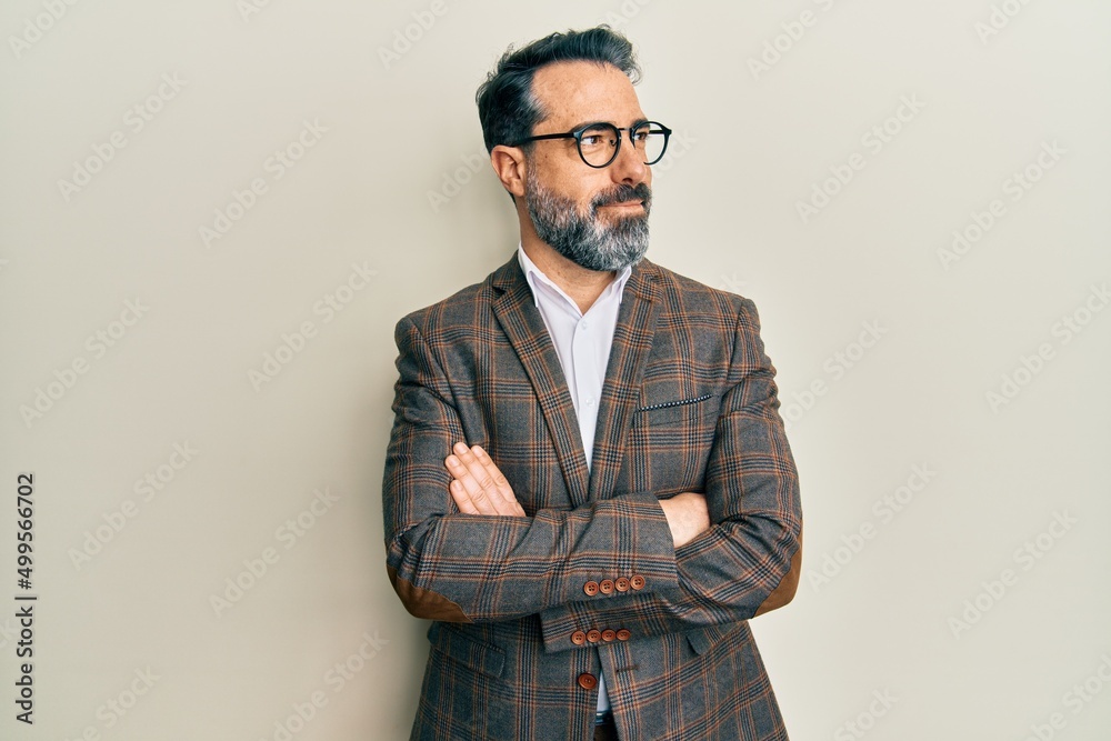Middle age man with beard and grey hair wearing business jacket and glasses smiling looking to the side and staring away thinking. Middle age man with beard and grey hair wearing business jacket and glasses smiling looking to the side and staring away thinking.