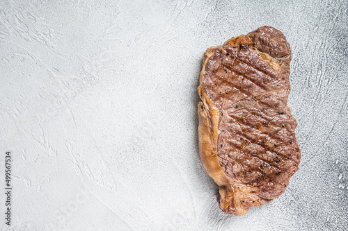 Grilled New York  striploin beef meat steak. White background. Top view. Copy space