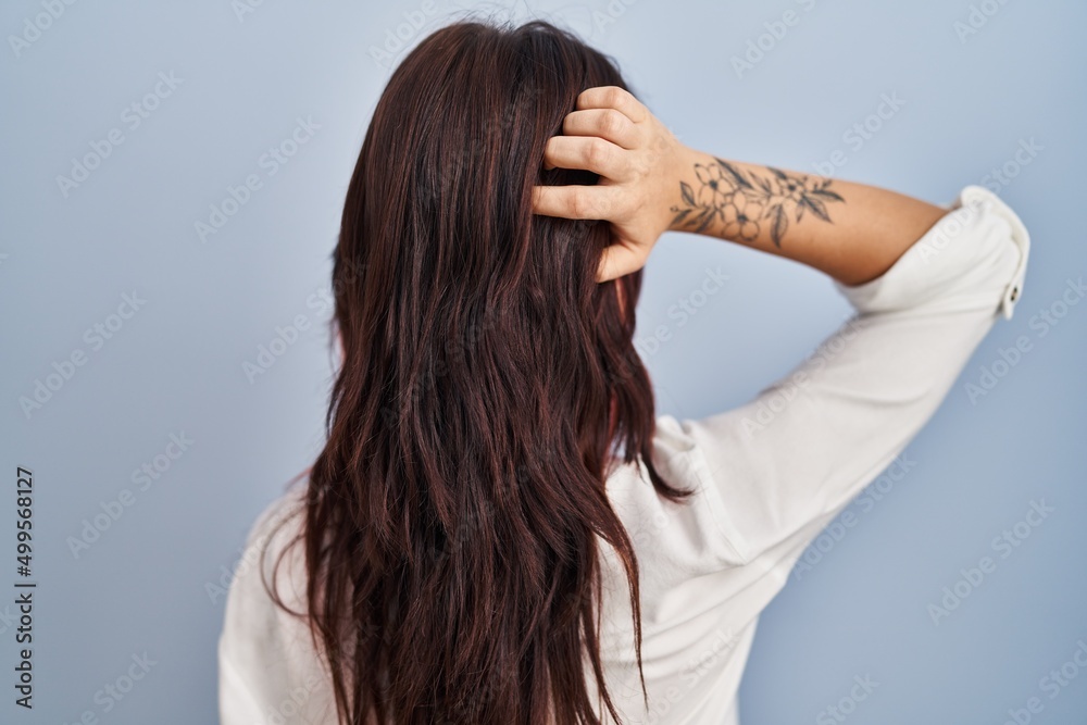 Young caucasian woman wearing casual white shirt over isolated background backwards thinking about doubt with hand on head Young caucasian woman wearing casual white shirt over isolated background backwards thinking about doubt with hand on head