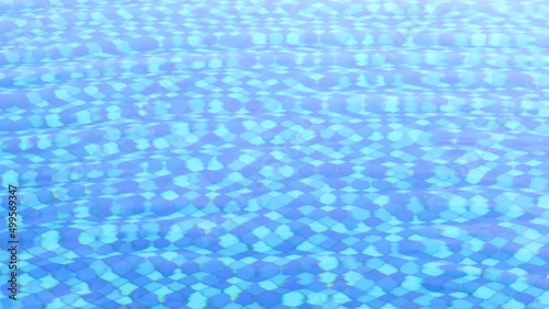 Wave pool with white and blue tiles on the bottom. Waves on the water. Background for sports and recreation. Active lifestyle.
