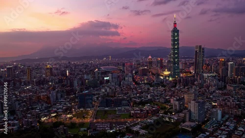Aerial timelapse of Downtown Taipei at sunset, the vibrant capital city of Taiwan, with 101 Tower standing out amid modern skyscrapers in XinYi Commercial District and city lights dazzling at dusk