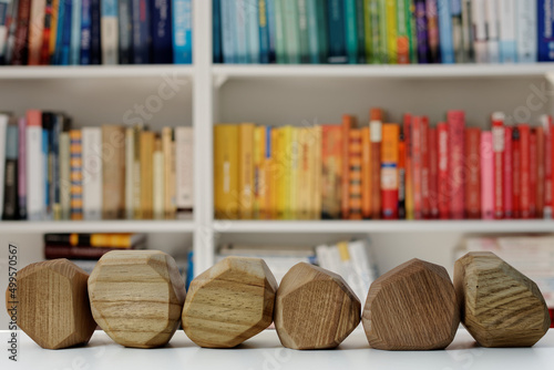 Six empty wooden blocks in front of home library. Blank wood blocks mockup and blurred bookshelf.