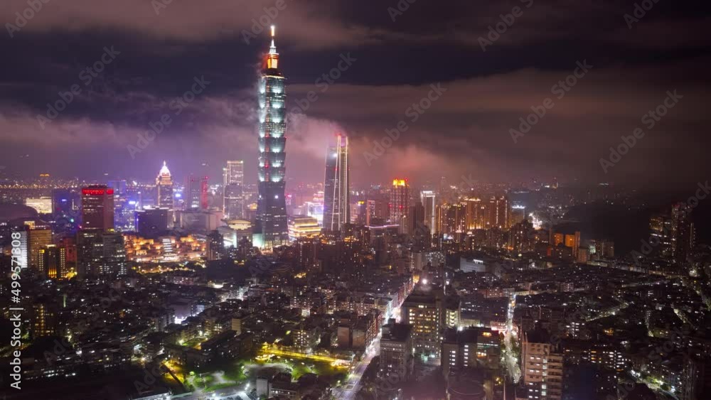 Aerial hyperlapse of Taipei, the vibrant capital of Taiwan, on a foggy evening, with 101 Tower standing out in Xinyi District, city lights dazzling in the dark and low clouds flowing among skyscrapers Aerial hyperlapse of Taipei, the vibrant capital of Taiwan, on a foggy evening, with 101 Tower standing out in Xinyi District, city lights dazzling in the dark and low clouds flowing among skyscrapers