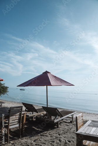 Sun umbrella and wooden beach beds on tropical coastline  Lombok  Indonesia