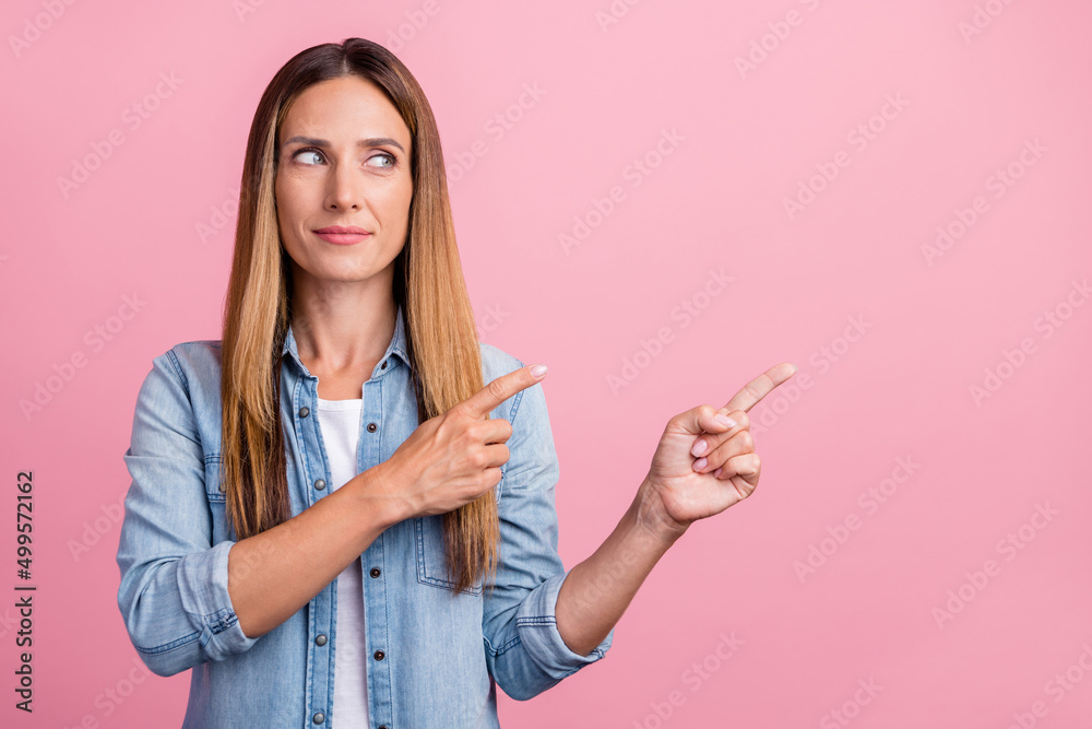 Photo of young pretty woman look indicate fingers empty space discount proposition isolated over pink color background Photo of young pretty woman look indicate fingers empty space discount proposition isolated over pink color background